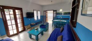 a living room with blue walls and a blue couch at Sobrado com piscina em condomíno fechado a 150 M da praia in Caraguatatuba