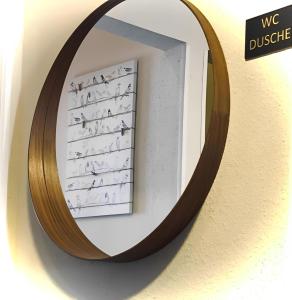 un miroir accroché à un mur avec un morceau d'écriture sur celui-ci, dans l'établissement Check-in Hamburg, à Hambourg