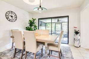 a dining room with a table and chairs and a clock at Canopy on Cobblestone in Wesley Chapel