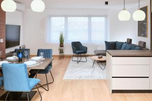 uma sala de estar com um sofá, uma mesa e cadeiras em apartman Azul em Čakovec