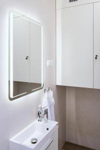 a white bathroom with a sink and a mirror at apartman Azul in Čakovec