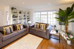 a living room with two couches and a table at Riverwalk Apartment North in Datchet