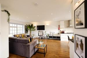 a living room with a couch and a table at Riverwalk Apartment North in Datchet