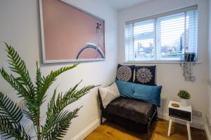 a living room with a chair and a plant at Riverwalk Apartment North in Datchet