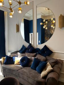 a large couch in a living room with a mirror at Family & Business Sauna Apartments Sienkiewicza Wesoła No 5 Centrum Downtown - 2 Bedroom with Private Sauna, Bath with Hydromassage, Parking - NEW! in Kielce