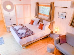 um quarto com uma cama e um sofá num quarto em Cabane Château hôtel luxe avec spa privatif Aulteribe - Le Peydébé em Vieille-Brioude