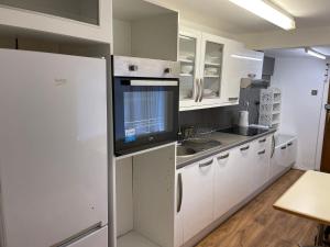 a kitchen with white cabinets and a refrigerator at Studio room in Brighton city centre in Brighton & Hove