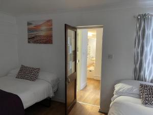 a bedroom with two beds and a door with a mirror at Studio room in Brighton city centre in Brighton & Hove