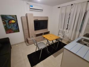 a kitchen with a table and chairs and a television at Departamento Planta Alta Ciudad Mendoza in Las Heras