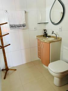 y baño con aseo, lavabo y espejo. en Apartamento - Praia da Armação do Pântano do Sul, en Florianópolis