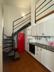 a kitchen with a staircase and a red refrigerator at Cleo Rosa in Ancona