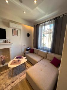 a living room with a couch and a table at Apartman Happiness in Sarajevo