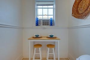 a small kitchen with two stools and a table with a window at Walkable Savannah Escape in Historic District! in Savannah
