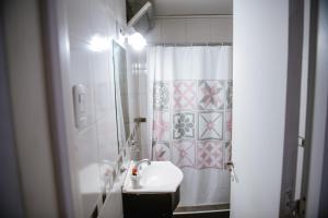 a bathroom with a sink and a shower curtain at Hotel Rosario in Mendoza
