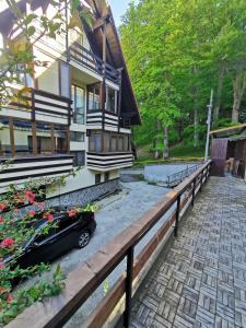 a house with a black car parked in front of it at Apartament Kalinderu K2 Busteni in Buşteni