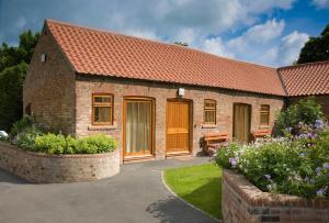 a brick house with a red roof at Filey Holiday Cottages in Filey