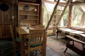 una camera con tavolo e sedie in legno e una scala a pioli di Cabaña Las Tejas a El Bolsón