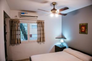 a bedroom with a ceiling fan and a window at Hotel Rosario in Mendoza