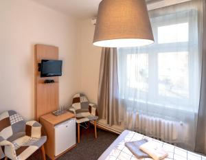 Pokój z łóżkiem, krzesłami i oknem w obiekcie Hotel U Berounky w mieście Srbsko
