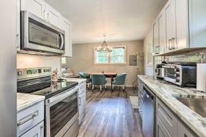 a kitchen with white cabinets and a dining room at Charming Retreat, 13 Mi to Grandfather Mtn! in Newland