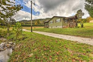 a house on a field with a dirt road at Charming Retreat, 13 Mi to Grandfather Mtn! in Newland