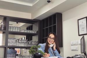 a woman sitting at a counter talking on a phone at Villa Miss in Bogatić
