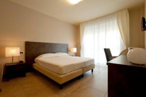 una camera con un grande letto e una finestra di Hotel Kent a Milano Marittima
