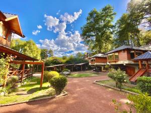 un grupo de casas con árboles y un camino de tierra en Villa Cümen en San Martín de los Andes