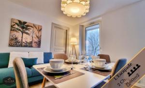 comedor con mesa y sofá en Les Appartements Neppert - Calme - Spacieux - Fibre - RBNB, en Mulhouse