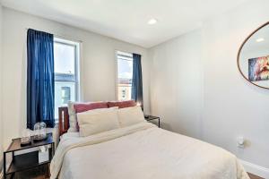 a bedroom with a bed and two windows at Central and Trendy Baltimore Townhome Pets OK! in Baltimore