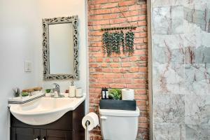 a bathroom with a white toilet and a brick wall at Central and Trendy Baltimore Townhome Pets OK! in Baltimore +15 photos
