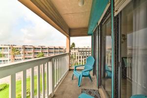 a balcony with a blue chair and a view at Sun-Soaked Texas Condo with North Beach Access! in Corpus Christi