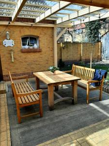 einem Holztisch und zwei Bänken unter einer Pergola in der Unterkunft Glashüttchen mit 2 Schlafzimmern, Sauna und schönem Garten in Annahütte