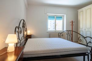 a bedroom with a bed and a cross in a window at Appartamenti PEN in Follonica