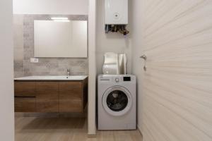 a bathroom with a washing machine and a sink at Appartamenti PEN in Follonica