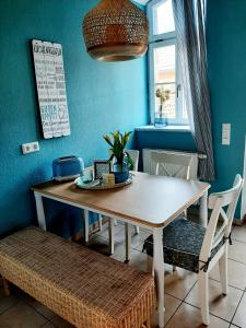 einen Tisch und Stühle in einem Zimmer mit blauer Wand in der Unterkunft Glashüttchen mit 2 Schlafzimmern, Sauna und schönem Garten in Annahütte