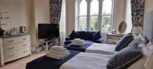 a hotel room with two beds and a tv at Mellington Hall Country House Hotel in Church Stoke