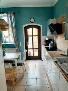 a kitchen with a table and a clock on the wall at Glashüttchen mit 2 Schlafzimmern, Sauna und schönem Garten in Annahütte