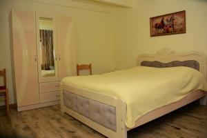 a bedroom with a large white bed and a mirror at The view of gora in Kutaisi