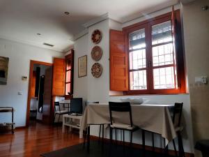 jadalnia ze stołem, krzesłami i oknami w obiekcie Apartamento El Rincón de Sancha w mieście Toledo