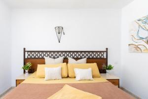 阿德耶Studio 50m from Puerto Colón Beach的卧室里有一张大床，上面有黄色枕头