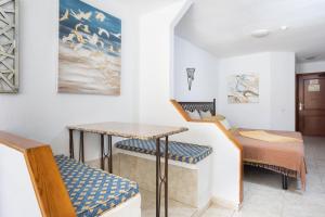 阿德耶Studio 50m from Puerto Colón Beach的一间有桌子、椅子和床的房间