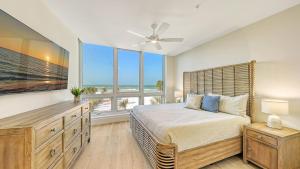 ein Schlafzimmer mit einem großen Bett und einem großen Fenster in der Unterkunft Ten35 Seaside Rentals in Sarasota