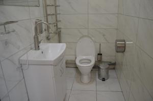 uma casa de banho branca com um WC e um lavatório em Хостел ПІД ФІКУСОМ em Ivano-Frankivsk
