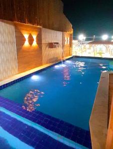 una piscina por la noche con una fuente de agua en Hotel Pousada Latitude, en Canoa Quebrada