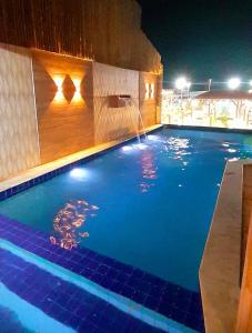 a swimming pool at night with a water fountain at Hotel Pousada Latitude in Canoa Quebrada