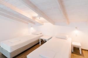 two beds in a room with white walls and wooden floors at PETRINO FOINIKOUNTA in Finikounta