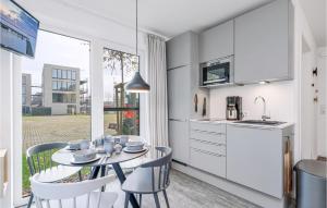 eine Küche und ein Esszimmer mit Tisch und Stühlen in der Unterkunft Cozy Apartment In Lembruchdümmer See in Lembruch