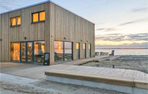 ein Gebäude auf einem Dock neben dem Wasser in der Unterkunft Cozy Apartment In Lembruchdümmer See in Lembruch