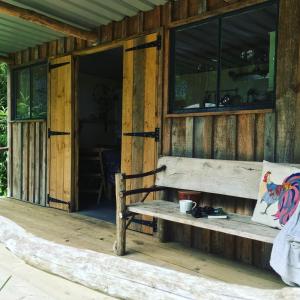 - un banc sur la terrasse couverte d'une cabane en bois dans l'établissement Barefoot Yurts, à Brede
